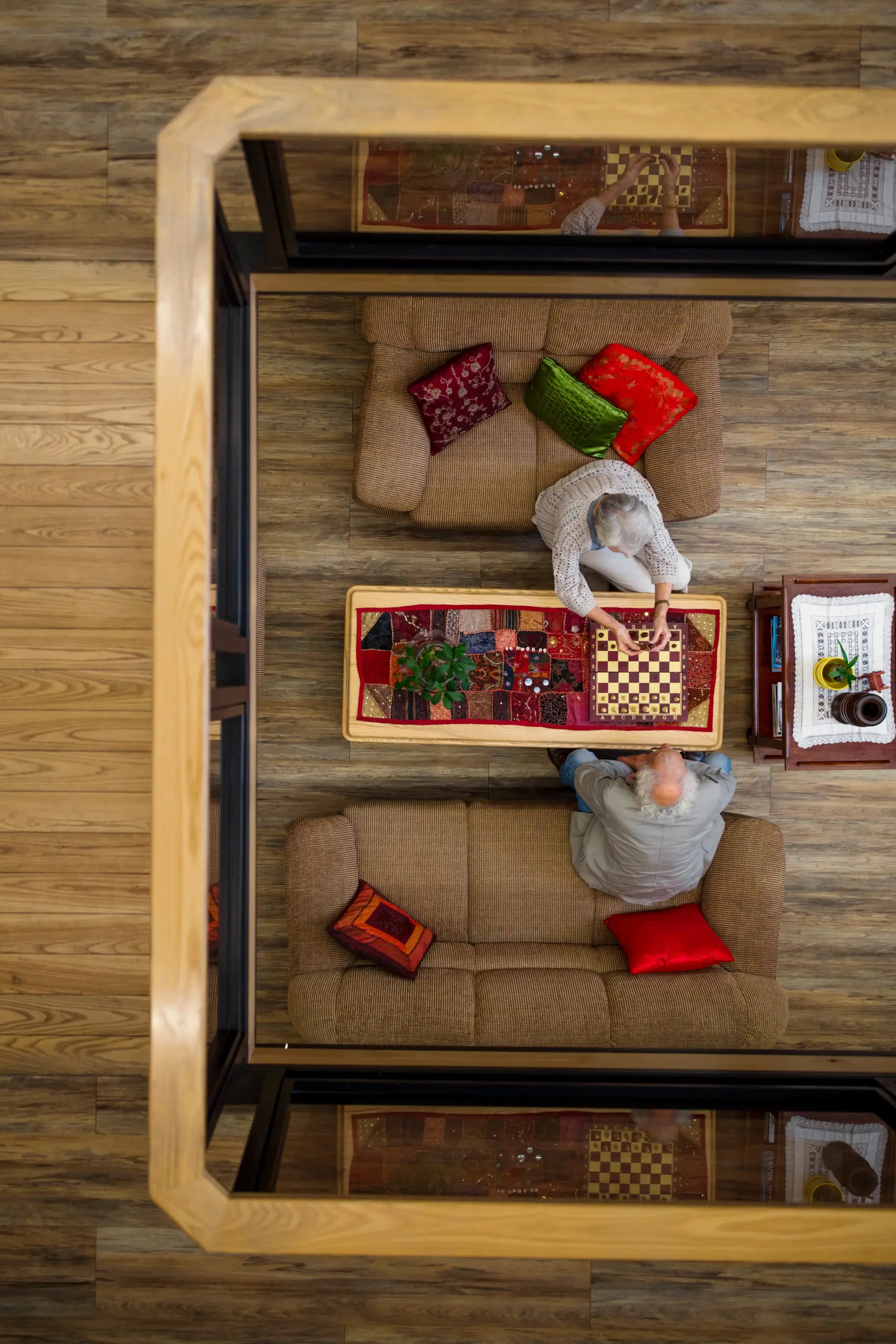 looking down on an elderly couple playing chess in the basement
